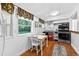 Bright kitchen with white cabinets, stainless steel appliances, and a dining table near the window at 815 E 11Th Ave, Mount Dora, FL 32757