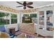 Bright room features a cabinet with a television, bookcase, and view of a garden at 815 E 11Th Ave, Mount Dora, FL 32757