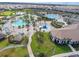 Aerial view of a community pool featuring palm trees, pools, lounge chairs and well manicured grounds at 8934 Stinger Dr, Davenport, FL 33896