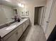 Bright bathroom with a double vanity, and gray tile flooring at 8934 Stinger Dr, Davenport, FL 33896