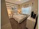 Comfortable bedroom with striped accent wall, plush bedding, and serene decor for a relaxing retreat at 8934 Stinger Dr, Davenport, FL 33896
