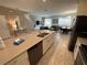 Modern kitchen with stainless steel appliances and an island breakfast bar connecting to the living area at 8934 Stinger Dr, Davenport, FL 33896
