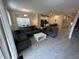Bright living space featuring open layout with a gray sectional sofa and kitchen view at 8934 Stinger Dr, Davenport, FL 33896