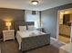 Comfortable bedroom featuring neutral colors, plush carpet, and a connected ensuite bathroom at 8934 Stinger Dr, Davenport, FL 33896