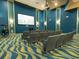 Community movie theater with rows of seating, blue walls, and a large screen for residents at 8934 Stinger Dr, Davenport, FL 33896