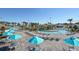 Community pool area with lounge chairs, tables, umbrellas, and surrounding greenery for residents to enjoy at 8934 Stinger Dr, Davenport, FL 33896