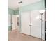 Bright bedroom features neutral carpet, fresh mint walls, and closet doors at 9188 Chandler Dr, Groveland, FL 34736