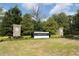 Stone-columned community entrance sign amid mature landscaping at 9188 Chandler Dr, Groveland, FL 34736