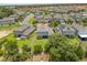 An aerial view of a neighborhood featuring tidy streets, manicured lawns, and homes with solar panels on their roofs at 922 Grazie Loop, Davenport, FL 33837