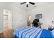 Comfortable bedroom featuring a ceiling fan, a blue striped bedspread, and wood floors at 922 Grazie Loop, Davenport, FL 33837