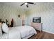 Inviting bedroom with light green wallpaper, wood floors, and a modern ceiling fan at 922 Grazie Loop, Davenport, FL 33837