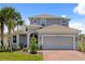 Charming two-story home with a well-manicured lawn and a spacious two-car garage with brick-paved driveway at 922 Grazie Loop, Davenport, FL 33837