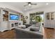 Comfortable living room with a plush sectional sofa, a large window with a view of the backyard, and custom built-ins at 922 Grazie Loop, Davenport, FL 33837