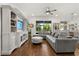 Bright and airy living room with a gray sectional sofa, a decorative ottoman, and custom built-in shelving and cabinets at 922 Grazie Loop, Davenport, FL 33837