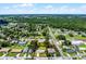 Aerial view of the house showcasing its location within a peaceful neighborhood with a backdrop of lush green trees at 1011 W 13Th St, Lakeland, FL 33805