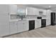 Modern kitchen featuring white cabinets, black appliances, quartz counters, and stylish backsplash at 1011 W 13Th St, Lakeland, FL 33805