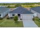 Aerial shot of home with solar panels, manicured front lawn, and a lake in the background at 1159 Mountain Flower Ln, Davenport, FL 33837