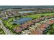 Panoramic aerial view of a golf community, showcasing homes surrounding a scenic lake and lush green golf course at 13232 Alderley Dr, Orlando, FL 32832