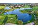 Aerial view of a well-maintained golf course with a fountain lake and lush landscaping in a serene setting at 13232 Alderley Dr, Orlando, FL 32832