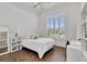 Bright bedroom featuring wood floors, a large window with shutters, and white walls for a calm and relaxing atmosphere at 13232 Alderley Dr, Orlando, FL 32832