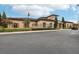 Exterior view of the clubhouse with stone accents, arched windows, and lush landscaping at 13232 Alderley Dr, Orlando, FL 32832