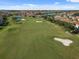 A beautiful aerial view of the community golf course featuring verdant greens, sand traps, and community homes in the background at 13232 Alderley Dr, Orlando, FL 32832