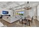 Open-concept living room with coffered ceilings, modern lighting, and sliding glass doors leading to the outdoor pool area at 13232 Alderley Dr, Orlando, FL 32832