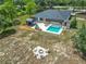 Aerial view of a property featuring a pool, outdoor kitchen, fire pit, and a spacious yard at 13735 Sw 73Rd St, Ocala, FL 34481