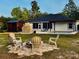Expansive backyard featuring a pool, outdoor kitchen, fire pit and lush green surroundings at 13735 Sw 73Rd St, Ocala, FL 34481