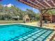 Spacious backyard featuring a pool, outdoor fireplace, and a charming gazebo at 13735 Sw 73Rd St, Ocala, FL 34481