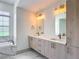 Bathroom vanity featuring double sinks, marble floors, and modern fixtures with a standalone tub at 13735 Sw 73Rd St, Ocala, FL 34481