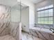 Elegant bathroom features a soaking tub, glass-enclosed shower, and luxurious marble accents, creating a spa-like experience at 13735 Sw 73Rd St, Ocala, FL 34481