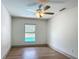 Bedroom featuring wood-look tile floors and a large window overlooking a beautiful, green backyard at 13735 Sw 73Rd St, Ocala, FL 34481