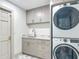 Modern laundry room features cabinets, countertop, sink, stacked washer/dryer, and tile flooring at 13735 Sw 73Rd St, Ocala, FL 34481
