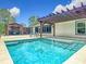 Beautiful in-ground pool surrounded by a concrete patio and an outdoor pergola with seating at 13735 Sw 73Rd St, Ocala, FL 34481