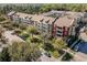 Aerial view of apartments with white balconies, surrounded by mature trees and street parking at 1400 Celebration Ave # 203, Celebration, FL 34747