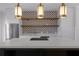 Contemporary kitchen with a cooktop island, floating wood shelves, and stainless appliances at 1400 Celebration Ave # 203, Celebration, FL 34747