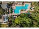 Bird's eye view of a large community pool with seating areas and cabanas, surrounded by palm trees at 1400 Celebration Ave # 203, Celebration, FL 34747