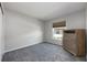 An empty bedroom with plush carpet, a large window, and a wood dresser at 1635 Little Falls Cir, Orlando, FL 32807