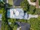 Overhead shot of a meticulously landscaped property with a metal roof, pool, and patterned driveway at 1820 Glencoe Rd, Winter Park, FL 32789