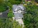 A stunning aerial view of the property featuring a metal roof, manicured lawns, and mature trees at 1820 Glencoe Rd, Winter Park, FL 32789
