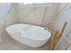 Elegant bathroom featuring a modern white tub with gold fixtures and marble wall at 1820 Glencoe Rd, Winter Park, FL 32789