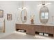 Bright bathroom featuring a double vanity with modern lighting, stylish mirrors, and white countertops at 1820 Glencoe Rd, Winter Park, FL 32789