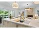 Kitchen island featuring a sink, marble countertops, and pendant lighting at 1820 Glencoe Rd, Winter Park, FL 32789