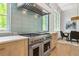 Gourmet kitchen featuring professional-grade range, custom hood, and eat-in dining at 1820 Glencoe Rd, Winter Park, FL 32789