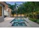 Backyard features a rectangular pool, in-ground spa, fire pit, and tropical landscaping at 1820 Glencoe Rd, Winter Park, FL 32789