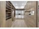 Bright walk-in closet features custom wood shelves, drawers, mirrored cabinets, and hardwood flooring at 1820 Glencoe Rd, Winter Park, FL 32789