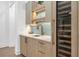 Custom wet bar with stone countertop, wood cabinets, and wine fridge at 1820 Glencoe Rd, Winter Park, FL 32789