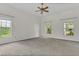 A spacious bedroom featuring neutral carpet, a ceiling fan, and a window at 19554 Spring Oak Dr, Eustis, FL 32736