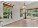 Bright dining area with tiled flooring, three large windows, and an elegant light fixture at 19554 Spring Oak Dr, Eustis, FL 32736